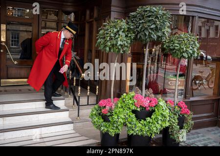 Un portier de l'hôtel prend un moment pour polir les surfaces en laiton à l'entrée de l'hôtel Reubens à Victoria, le 17th avril 2023, à Londres, en Angleterre. Banque D'Images