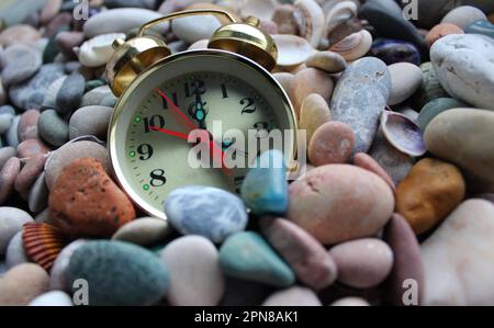 Horloge rare avec des cloches parsemées de petits cailloux sur le bord de mer Banque D'Images