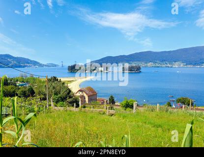 Plage de sable de Cesantes ville et l'île de San Simon (Galice, Espagne). Paysage d'été Ria de Vigo. Banque D'Images