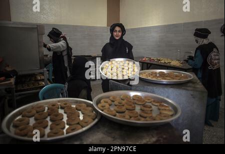 Gaza, Palestine. 17th avril 2023. Les femmes palestiniennes préparent des cookies de date traditionnels dans la ville de Gaza pour les distribuer aux familles défavorisées avant le prochain Eid al-Fitr, qui marque la fin du mois de jeûne musulman. Crédit : SOPA Images Limited/Alamy Live News Banque D'Images