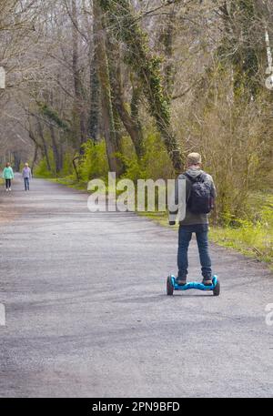 Un jeune homme passe son sweat à capuche le long de la piste publique de randonnée, de vélo et de jogging Virgiia Creeper à Abingdon, en Virginie. Banque D'Images