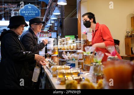 La vie quotidienne des vendeurs et des acheteurs sur le marché couvert beaucoup de ventes beaucoup achètent des fruits, des légumes et d'autres produits en vente mode masque pour les vendeurs 2023 Canada Vancouver Banque D'Images