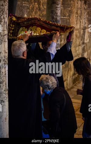 Les croyants viennent à l'église byzantine de Panagia Kapnikarea pendant l'Epitaph (Vendredi Saint), passant sous un tapis qui représente l'Epitaph. Banque D'Images