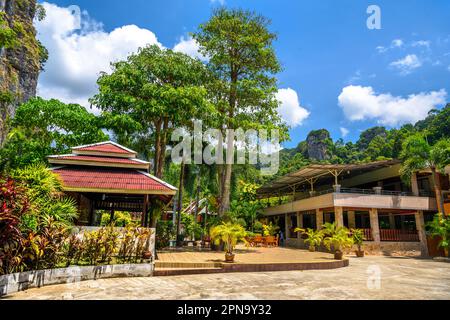 Maisons et différents palmiers dans le village sur la plage de Railay à l'ouest, Ao Nang, Krabi, Thaïlande. Banque D'Images