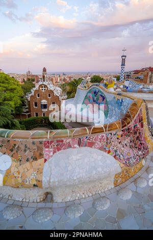 Bancs avec mosaïque colorée, bâtiment d'entrée à l'arrière, Casa de la Guardia, Pabellon de Porteria, vue sur la ville dans la lumière du soir Banque D'Images