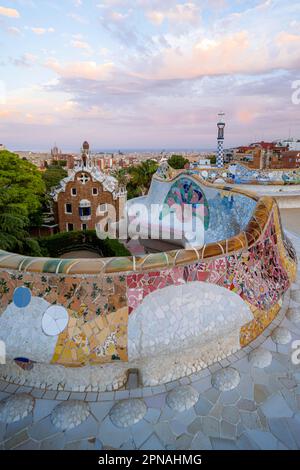 Bancs avec mosaïque colorée, bâtiment d'entrée à l'arrière, Casa de la Guardia, Pabellon de Porteria, vue sur la ville dans la lumière du soir Banque D'Images