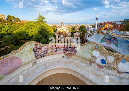 Bancs avec mosaïque colorée, bâtiment d'entrée à l'arrière, Casa de la Guardia, Pabellon de Porteria, vue sur la ville dans la lumière du soir Banque D'Images