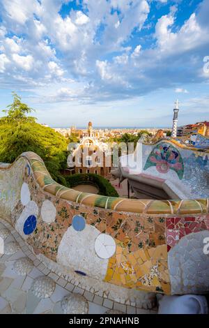 Bancs avec mosaïque colorée, bâtiment d'entrée à l'arrière, Casa de la Guardia, Pabellon de Porteria, vue sur la ville dans la lumière du soir Banque D'Images