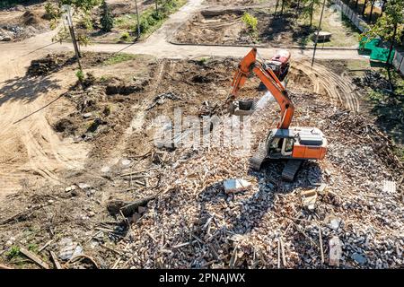 pelle hydraulique travaillant sur un tas de débris d'un bâtiment démonté sur un site de démolition. vue aérienne. Banque D'Images