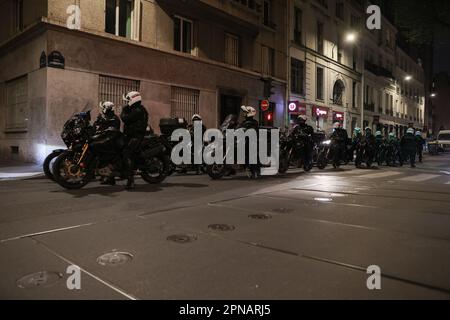 Paris, France. 17th avril 2023. Paris, France. 17th avril 2023. Les officiers de police de la répression de la Brigade motorisée d'action violente (Brav-M ou Brigade de répression de l'action viole automobile) passent devant des corbeilles brûlées suite à un concert de casseroles pour protester lors de l'allocution télévisée du Président Emmanuel Macron devant la nation, après avoir signé une réforme des retraites, à Paris, La France sur 17 avril 2023. Photo de Christophe Michel/ABACAPRESS. Credit: Abaca Press/Alay Live News Banque D'Images