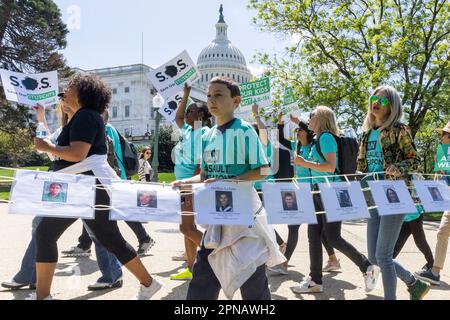 (230418) -- WASHINGTON, D.C., 18 avril 2023 (Xinhua) -- des personnes montrent des photos des victimes de violence par armes à feu pendant une marche au Capitole pour protester contre une interdiction des armes d'assaut, à Washington, DC, les États-Unis, sur 17 avril, 2023. Quatre personnes ont été tuées et au moins 28 autres blessées lors d'une fusillade à l'occasion d'une fête d'anniversaire samedi soir dans la petite ville de Dadeville, en Alabama, aux États-Unis, ont déclaré les autorités dimanche. Cet incident a conduit les États-Unis à une triste étape de plus de 160 fusillades de masse jusqu'à présent cette année, avec 12 277 morts par la violence par armes à feu, selon une base de données r Banque D'Images