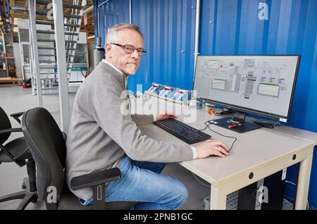 PRODUCTION - 05 avril 2023, Hambourg : Thomas Willner, ingénieur en procédés et chef de projet de Readi-PTL (distillation réactive), est installé sur un moniteur de l'usine avec un réacteur de conversion des déchets (graisses usagées) dans l'usine pilote du département d'ingénierie des procédés du campus des sciences de la vie de la HAW. L'usine pilote est conçue pour convertir les déchets tels que les matières grasses usagées et les déchets de plastique en substituts de pétrole sans pétrole lourd neutre en carbone. Le substitut de pétrole (huile végétale fissurée CVO) peut être utilisé pour produire des carburants liquides tels que l'essence et le diesel, ainsi que des plastiques et beaucoup de M. Banque D'Images