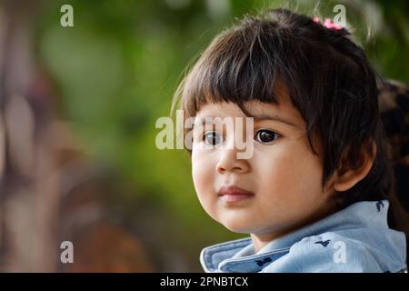 Gros plan de petite fille indienne mignonne, à droite, image extérieure horizontale, Pune, Maharashtra, Inde. Banque D'Images