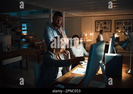 Plus rapide grâce à la saisie de tous les éléments. groupe d'hommes d'affaires travaillant tard dans un bureau. Banque D'Images