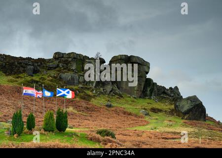 Nuages sombres au-dessus de Cow & Calf (rochers) et drapeaux sur les collines de la lande soufflant (site touristique populaire de la campagne) - Ilkley, West Yorkshire, Angleterre, Royaume-Uni. Banque D'Images