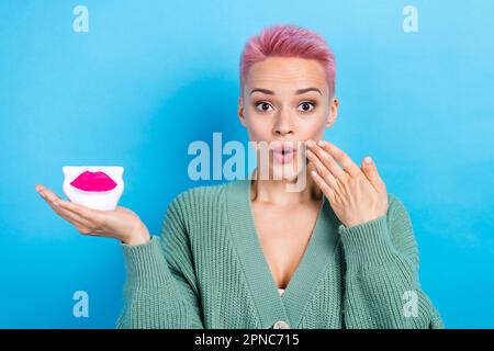 Portrait de la femme impressionnée bras tenir les lèvres faciales choqué grandes lèvres rêve de botox injection isolée sur fond bleu de couleur Banque D'Images