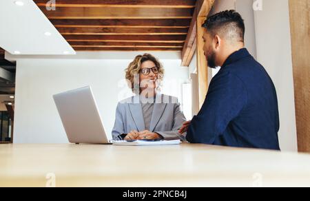 Deux hommes d'affaires ayant une réunion. Homme et femme se parlent dans un bureau. collègues professionnels discutant au travail. Banque D'Images