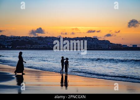 Tanger, Maroc 2022 : silhouette d'enfant dans un coucher de soleil pittoresque sur la promenade du front de mer Banque D'Images