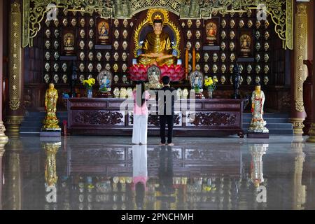 Temple bouddhiste de Phat Quang. Siddhartha Gautama, le Bouddha Shakyamuni. Jeune couple priant. Chau Doc. Vietnam. Banque D'Images