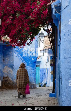 Chefchaouen, Maroc 2022: Les gens marchent dans les rues étroites et colorées de la ville bleue de Chefchaouen,. attraction touristique populaire Banque D'Images