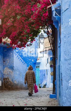 Chefchaouen, Maroc 2022: Les gens marchent dans les rues étroites et colorées de la ville bleue de Chefchaouen,. attraction touristique populaire Banque D'Images