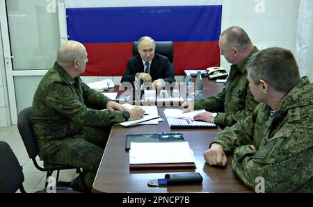 Région de Kherson, Ukraine. 18th avril 2023. Une capture d'écran publiée par le bureau de presse présidentiel russe sur 18 avril 2023 montrant le président russe Vladimir Poutine rencontre avec le commandant des forces aériennes russes, le colonel général Mikhail Teplinsky, à droite, le lieutenant-général Andrey Kuzmenko, 2nd à droite, Et le colonel général Oleg Makarevitch, qui est parti, commandant des forces du Dnepr au quartier général du groupement tactique du Dnepr, à 17 avril 2023, dans la région occupée de Kherson en Ukraine. Crédit : Bureau de presse présidentiel russe/Pool du Kremlin/Alamy Live News Banque D'Images