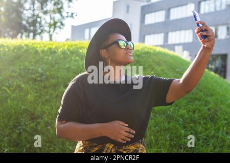 Femme africaine attirante prenant le selfie dans la rue portant des lunettes - concept millénaire et génération z Banque D'Images