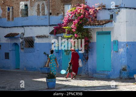 Chefchaouen, Maroc 2022: Les gens marchent dans les rues étroites et colorées de la ville bleue de Chefchaouen,. attraction touristique populaire Banque D'Images