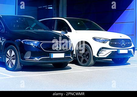 Mercedes-Benz EQA 250 noir batterie SUV électrique année 2023 et nouveau blanc Mercedes-Benz 4MATIC SUV en lumière bleue. Salo, Finlande. 10 avril 2023. Banque D'Images