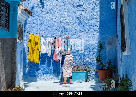 Chefchaouen, Maroc 2022: Les gens marchent dans les rues étroites et colorées de la ville bleue de Chefchaouen,. attraction touristique populaire Banque D'Images