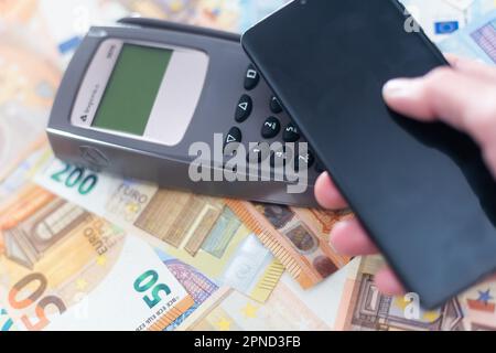 Transaction de paiement avec un smartphone ou des billets en euros. Banque D'Images