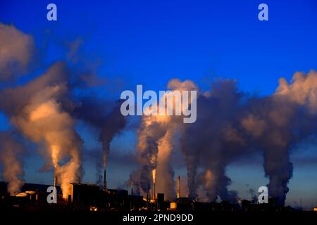 Les cheminées d'usine qui déversent la pollution dans le ciel fument des polluants qui augmentent dans l'air Banque D'Images