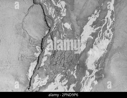 La structure de la terre mouillée fissurée au fond du lac, créant des patrons, structure, arrière-plan irréguliers. Des formes étonnantes créées par la nature à Banque D'Images