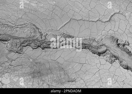 La structure de la terre mouillée fissurée au fond du lac, créant des patrons, structure, arrière-plan irréguliers. Des formes étonnantes créées par la nature à Banque D'Images
