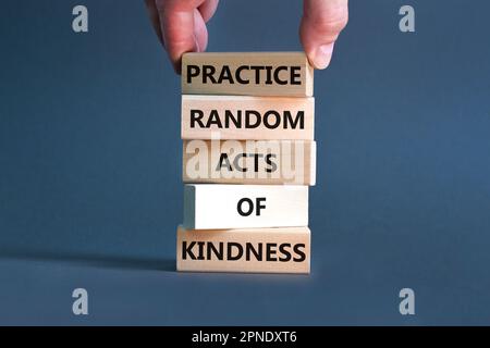 Pratiquer le type aléatoire de symbole de bonté. Concept mots pratique aléatoire genre de bonté sur bloc de bois. Magnifique fond gris. Main d'homme d'affaires. Banque D'Images