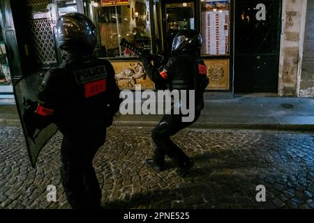 Jan Schmidt-Whitley/le Pictorium - 17/4/2023 - France / Paris / Paris - un membre de la BRAV-M tire des gaz lacrymogenes rue de la Contre Escarpe Forcant les restaurants a fermer et les clients a se proteger des effets des gaz. Plusieurs milliers de personnes se sont reunies dévorant la mairie du 10e arrondissement de Paris pour protester contre la politique d'Emmanuel Macron et contre la reforme des traitites. Plusieurs centaines de personnes ont ensuite cours Paris pendentif plusieurs heures en forme de multiples corteges sauves et jouant au chat et a la souris avec les forces de l'o Banque D'Images