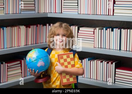 Garçon d'école avec le monde et les échecs, l'enfance. École enfant étudiant en apprentissage, étudier la langue ou la littérature à l'école. Enfant de l'école primaire Banque D'Images