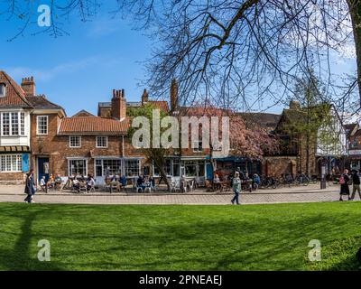 ST WILLIAM'S COLLEGE, YORK, ROYAUME-UNI - 17 AVRIL 2023. Touristes et locaux assis aux tables extérieures des cafés locaux dans le centre de York sur une somme ensoleillée Banque D'Images