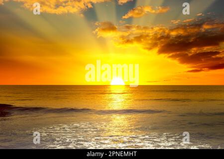 Lever de soleil majestueux et lumineux sur l'océan et vagues de lumière sur la mer bleue. Banque D'Images