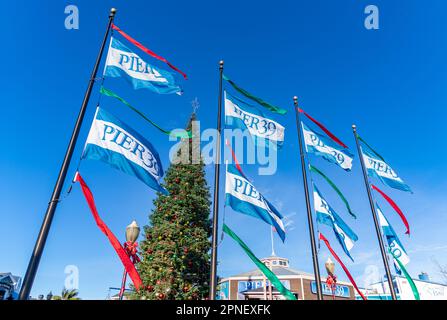 Une photo des drapeaux de l'embarcadère 39, avec un arbre de Noël à l'arrière. Banque D'Images