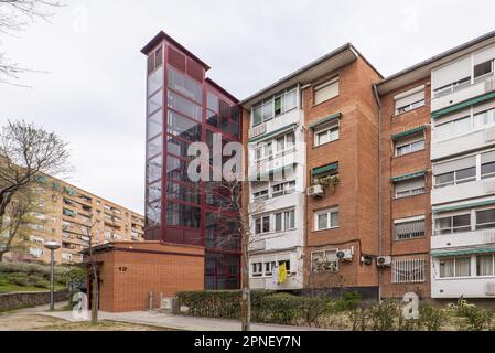 Façades de bâtiments résidentiels avec un ascenseur en métal rouge annexe avec fenêtres teintées Banque D'Images