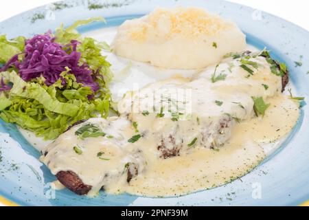 Délicieux steak grillé accompagné de sauce au fromage, servi avec une salade et une purée de pommes de terre. Banque D'Images