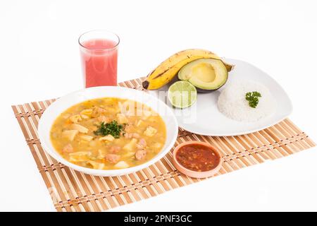 Savoureuse cuisine colombienne typique ; Mondongo de soupe avec avocat, banane et riz blanc. Banque D'Images
