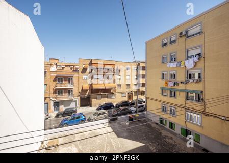 Un terrain vide entre les bâtiments sur une rue étroite dans un quartier de Madrid par une belle journée d'été Banque D'Images