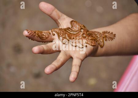 Srinagar, Inde. 18th avril 2023. Un enfant montre ses mains avec des tatouages de Henna 'mehandi' la technique de colorer la peau avec une teinte naturelle de rouge au marché de Srinagar Goni khan, pendant les préparatifs pour le festival d'Eid, c'est un jour religieux de la tradition islamique. Cela signifie la célébration de la fin du Ramadan. Sur 18 avril 2023 à Srinagar, Inde. (Credit image: © Umer Bin Qadir/eyepix via ZUMA Press Wire) USAGE ÉDITORIAL SEULEMENT! Non destiné À un usage commercial ! Banque D'Images