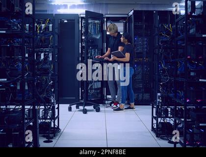 Les techniciens travaillant dans la salle des serveurs Banque D'Images