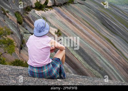 Australie, Nouvelle-Galles du Sud, parc national de Bald Rock, femme regardant des montagnes à rayures multicolores Banque D'Images