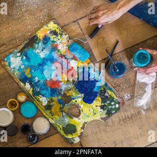 Vue en grand angle des pinceaux, de la palette, des huiles, des acryliques et d'autres éléments d'un artiste peintre. Atelier d'art. Arrière-plan. Banque D'Images