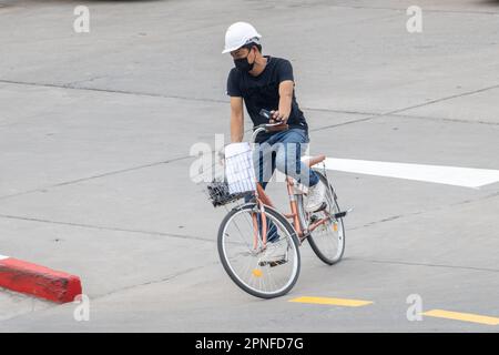 SAMUT PRAKAN, THAÏLANDE, JANVIER 31 2023, Un homme dans un casque de protection conduit un vélo Banque D'Images