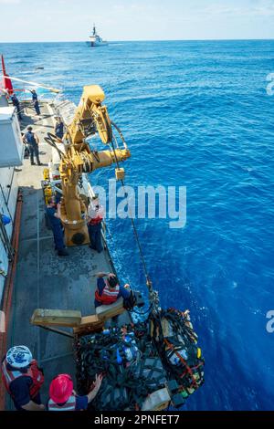 Équipe de pont des États-Unis Coast Guard Cutter Active (WMEC 618) se prépare à transférer des balles de marijuana à l'aide d'une grue davit aux États-Unis Le Cutter Waesche de la Garde côtière (LMSM 751) dans l'océan Pacifique oriental, au 25 mars 2023. Actif et équipage ont détecté et saisi plus de 100 balles de marijuana dans les eaux internationales. (É.-U. Photo de la Garde côtière par Petty Officer 2nd classe Justin Upshaw). Banque D'Images